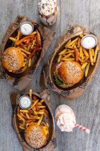 burgery z frytkami i ketchupem truskawkowy shake lodowy tardycyjna kuchnia amerykańska